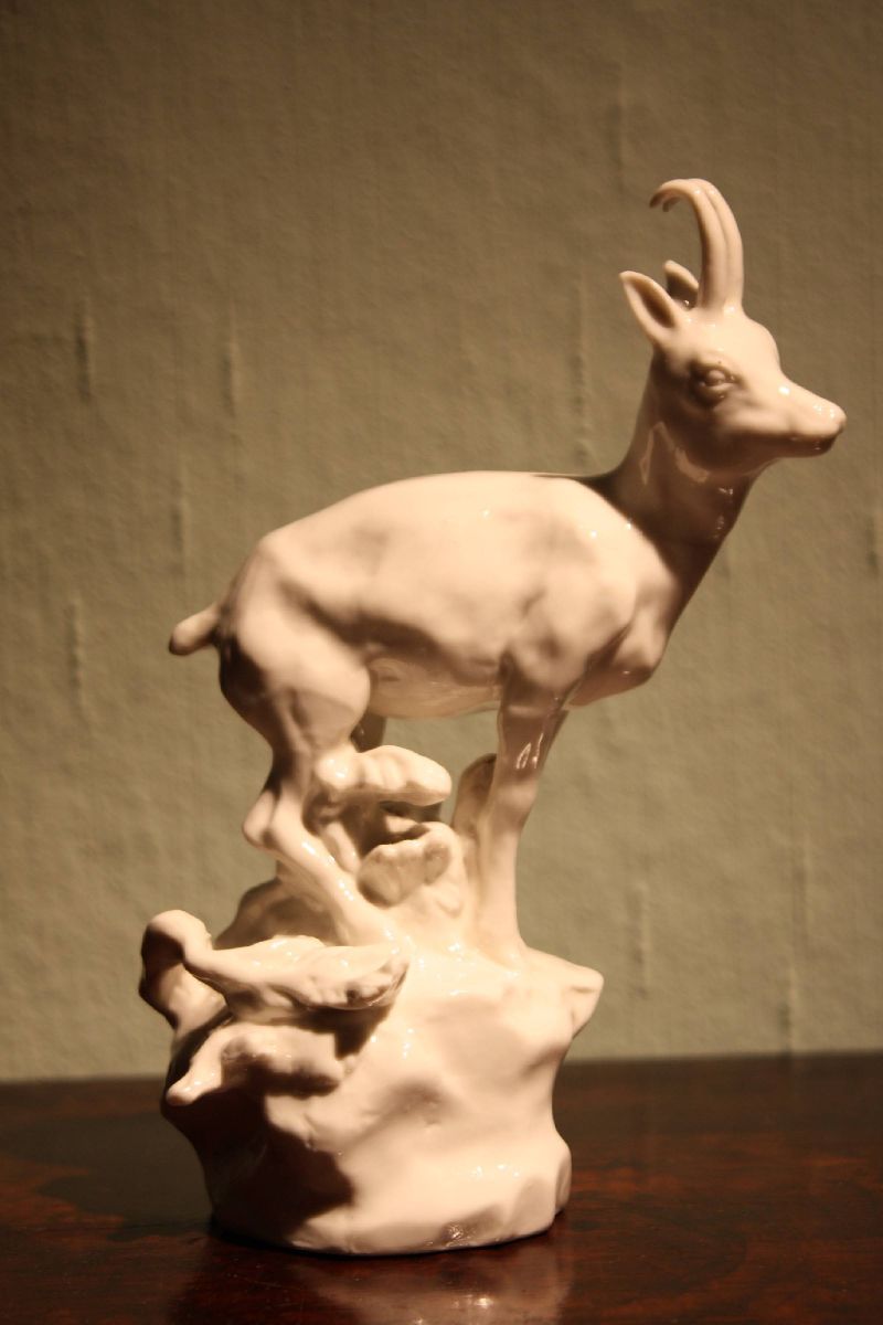 A small vintage all white glazed porcelain figurine chamois buck on a rock, made around 1900 by Nymphenburg