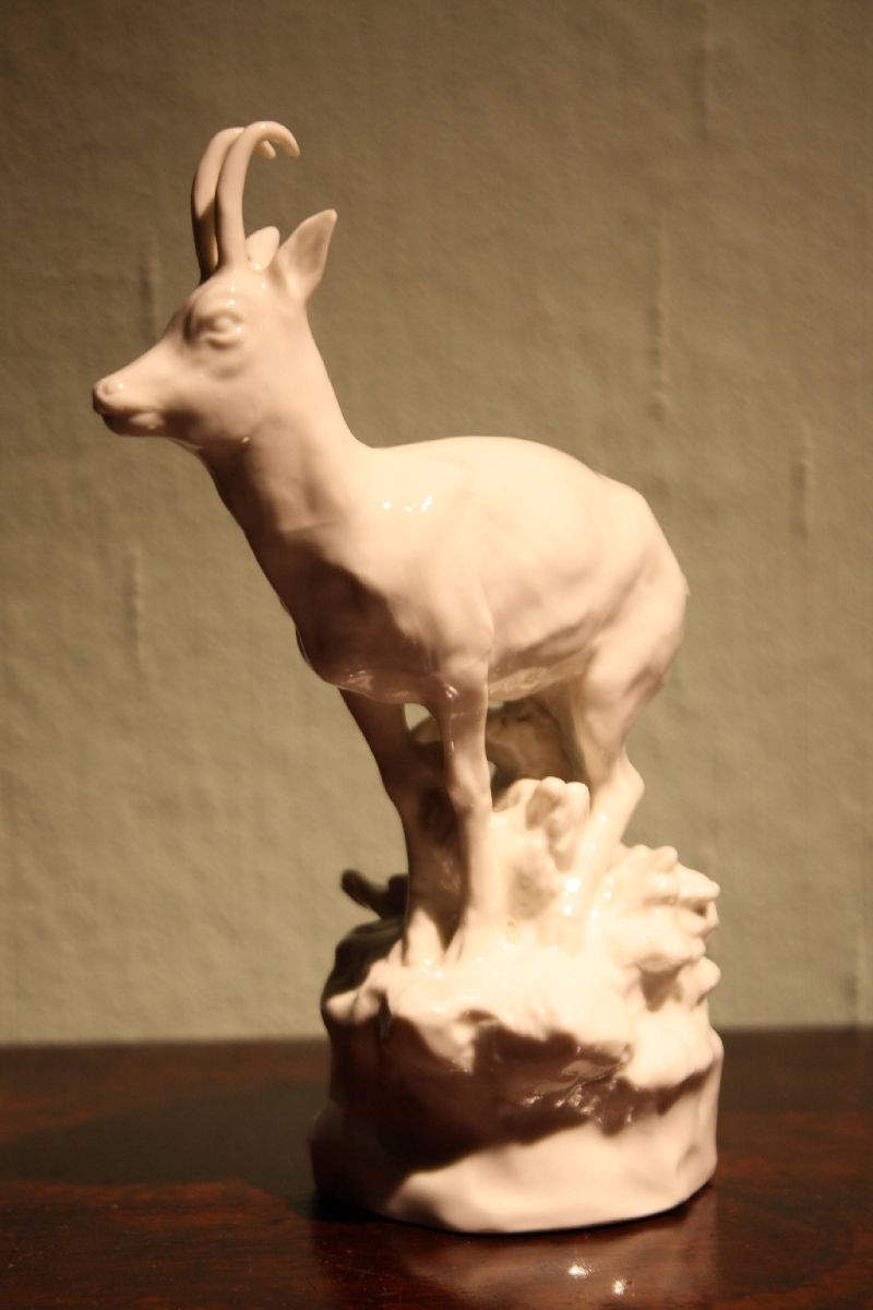 A small vintage all white glazed porcelain figurine chamois buck on a rock, made around 1900 by Nymphenburg