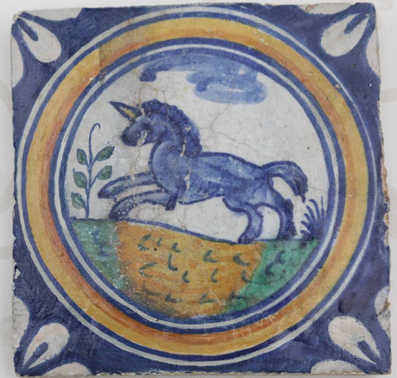 A rare 1600 hand-painted polychrome Delft stonework medallion tile, showing a running unicorn