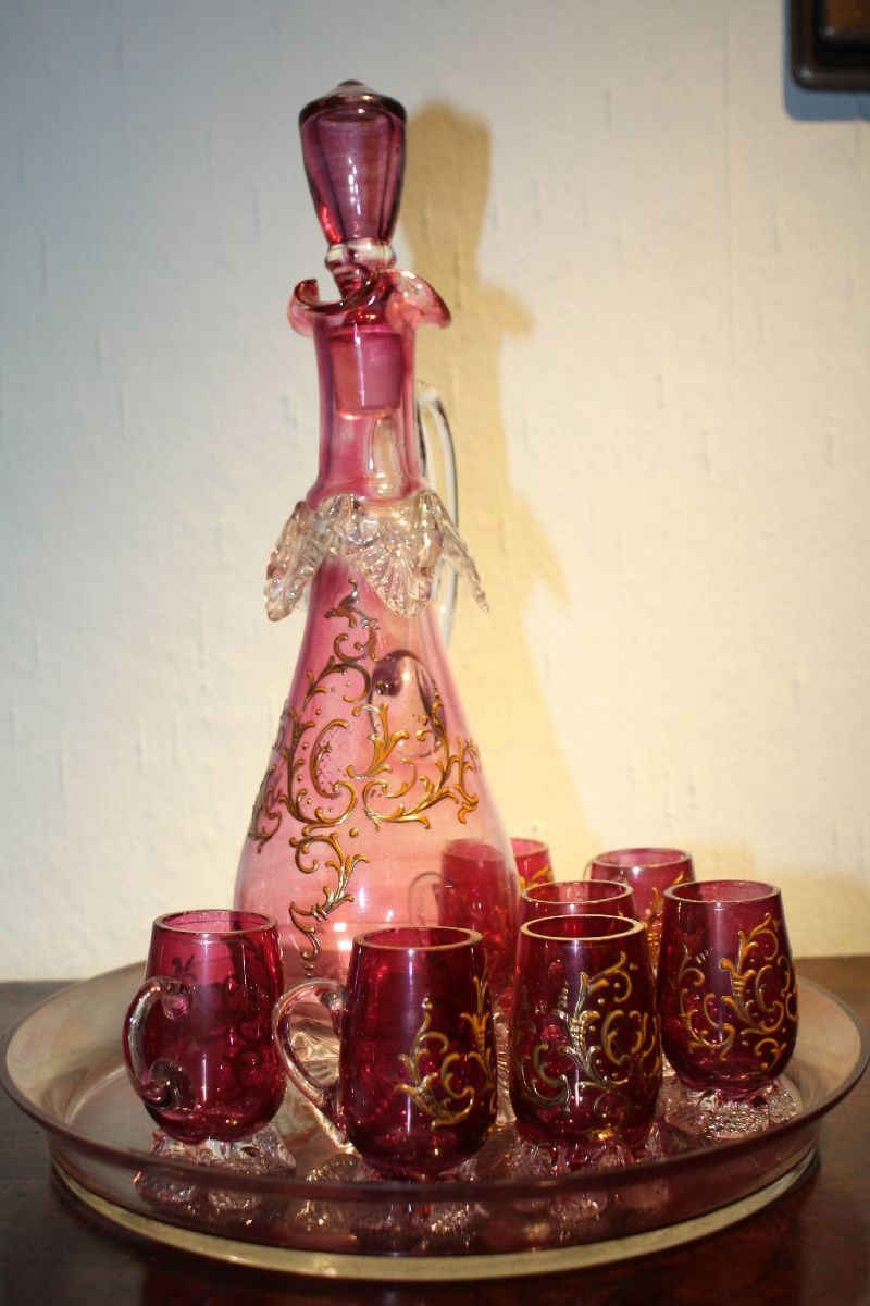 A vintage 1900 Bohemian pink glass ornate rocailles liquor pitcher with 7 glasses on a tray