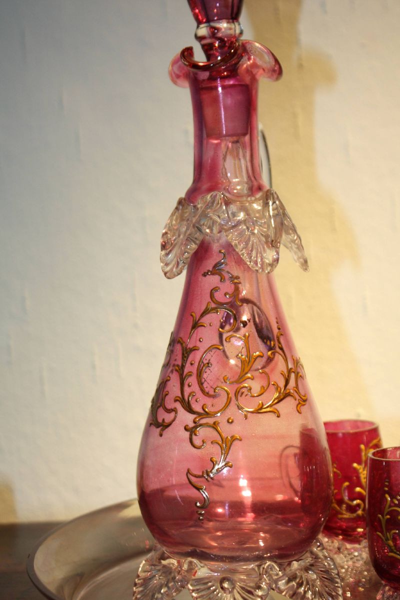 A vintage 1900 Bohemian pink glass ornate rocailles liquor pitcher with 7 glasses on a tray