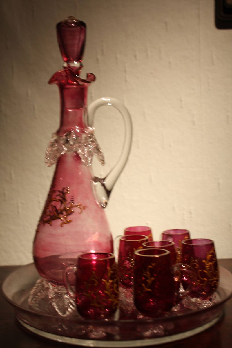 A vintage 1900 Bohemian pink glass ornate rocailles liquor pitcher with 7 glasses on a tray