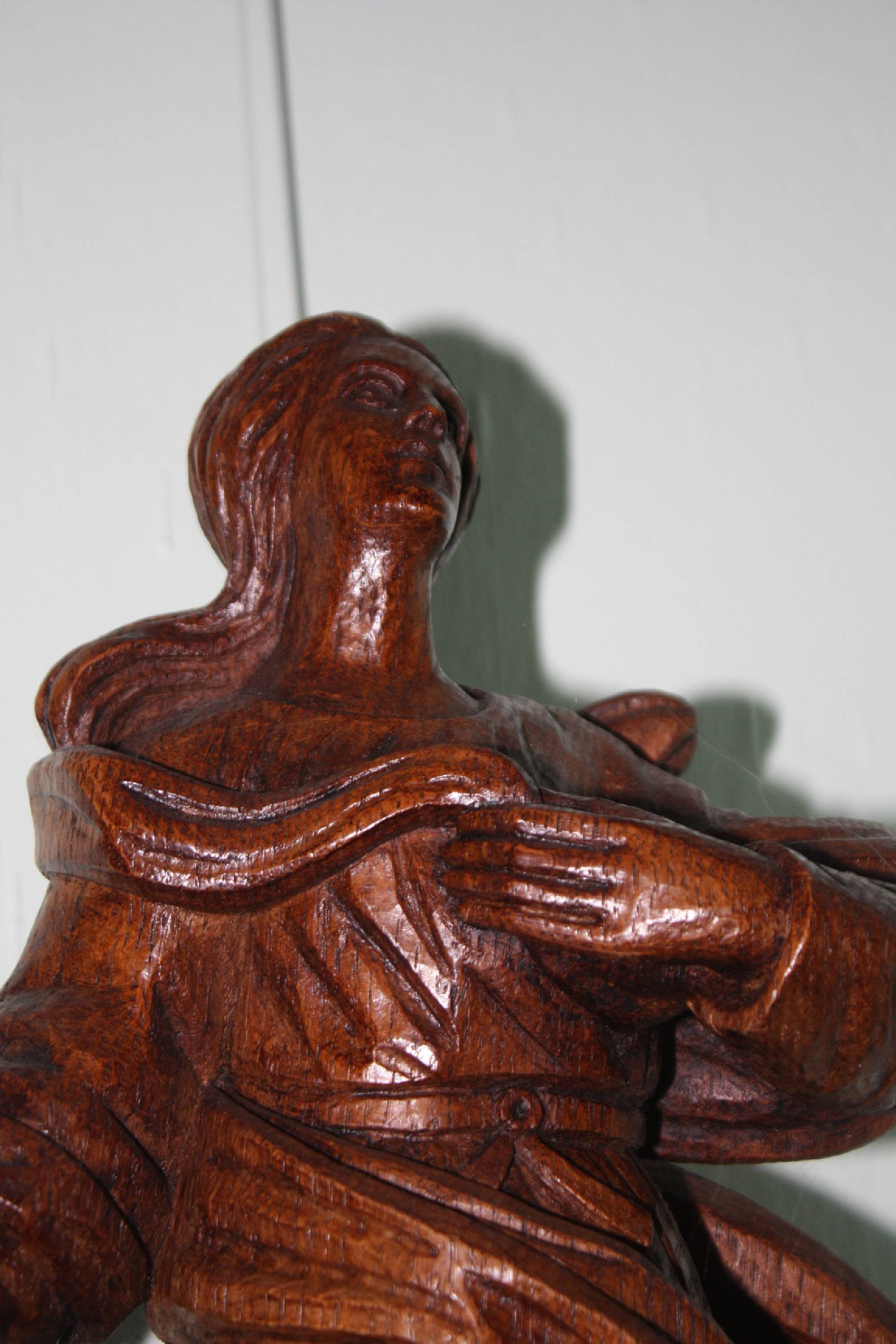 A large wooden 20th century handcarved Virgin Mary treading on a snake figure wall statue