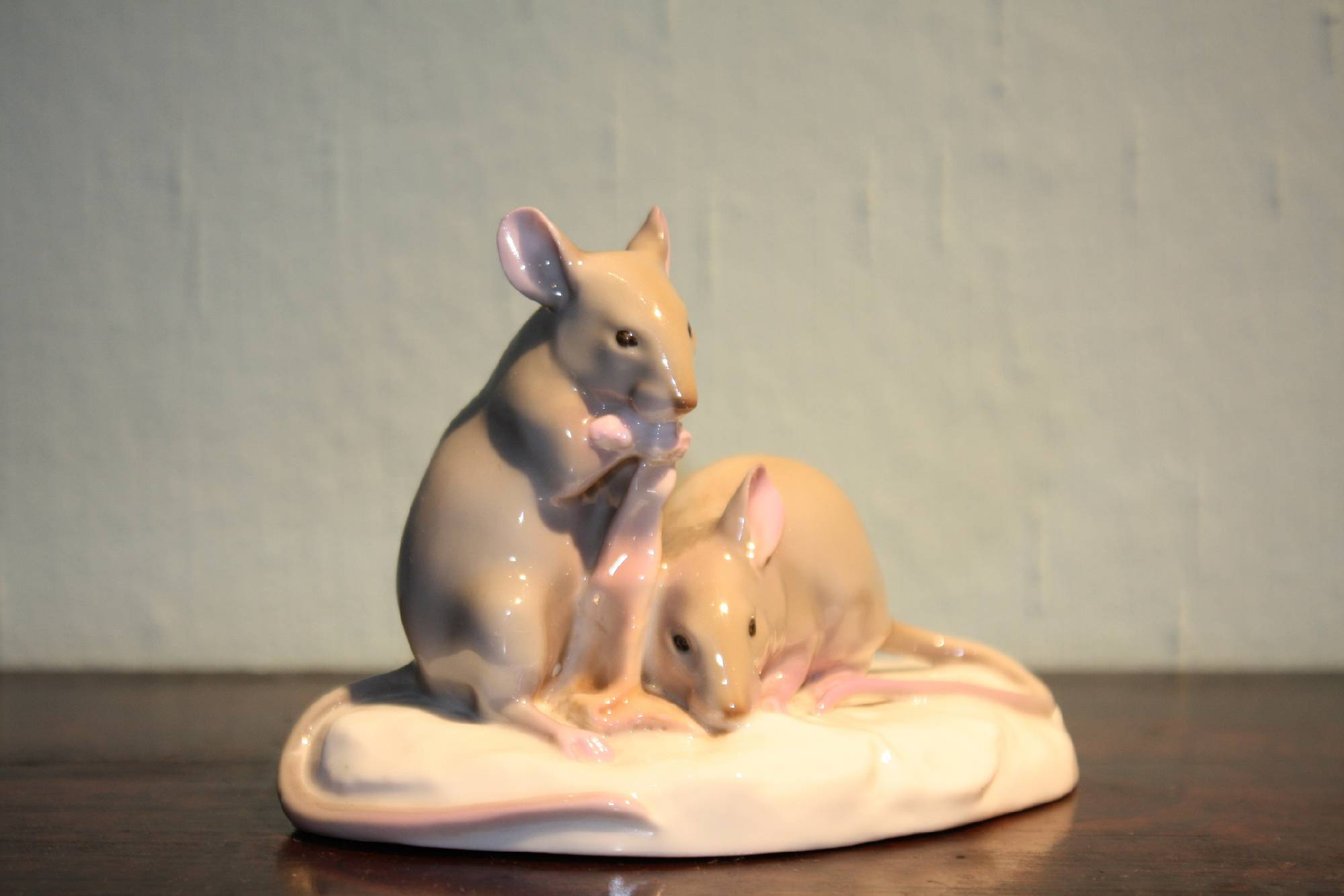 A small rare 1910 hand-painted porcelain figure of two mice eating bacon, signed by Nymphenburg