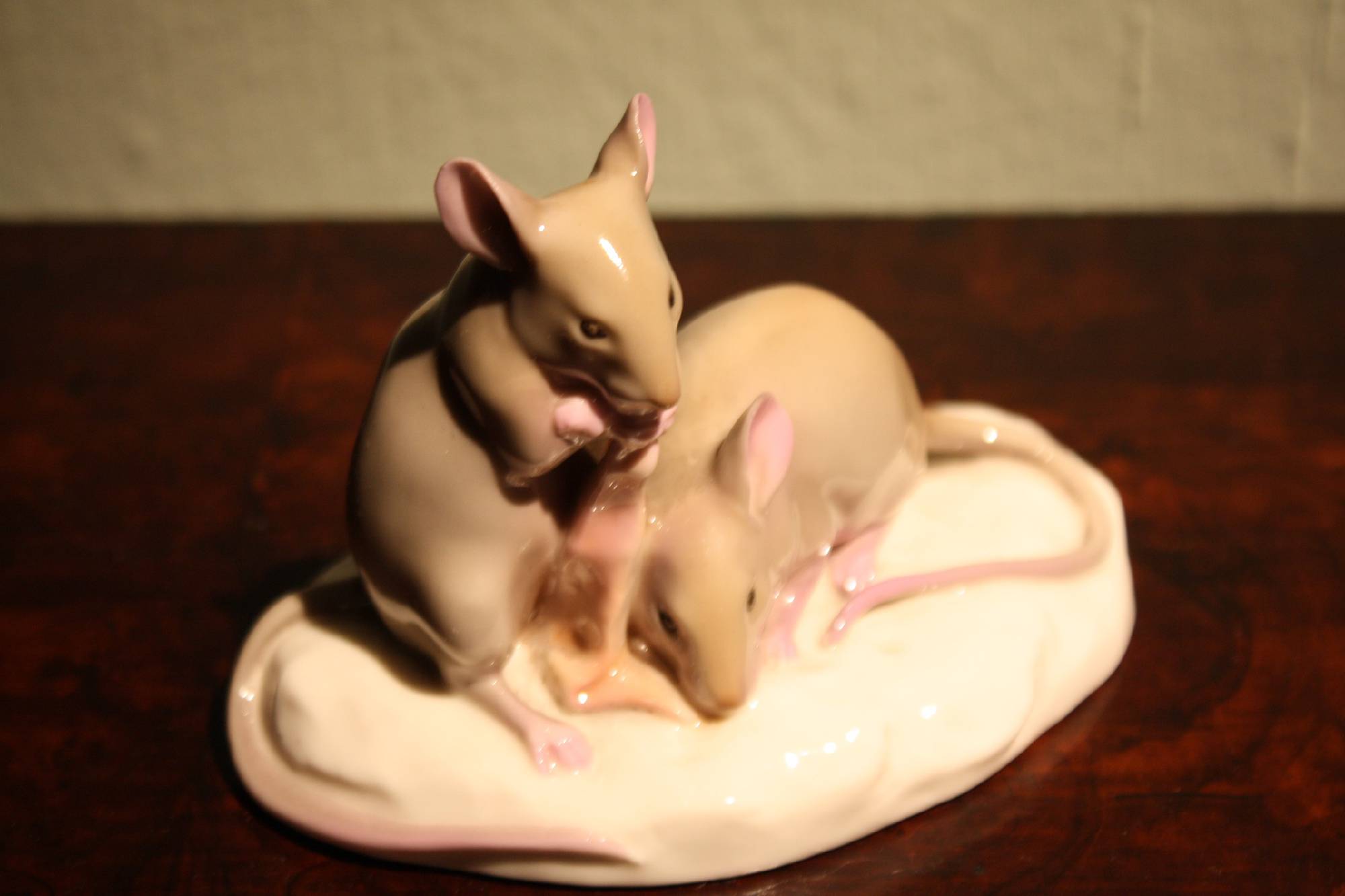 A small rare 1910 hand-painted porcelain figure of two mice eating bacon, signed by Nymphenburg