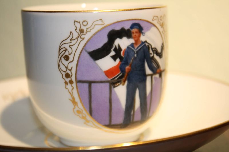 A precious early 20th century German patriotic porcelain collectable Meissen cup and saucer, cup with a hand-painted first world war sailor in front of the German war flag on it. Saucer with annual figures 1914-1916