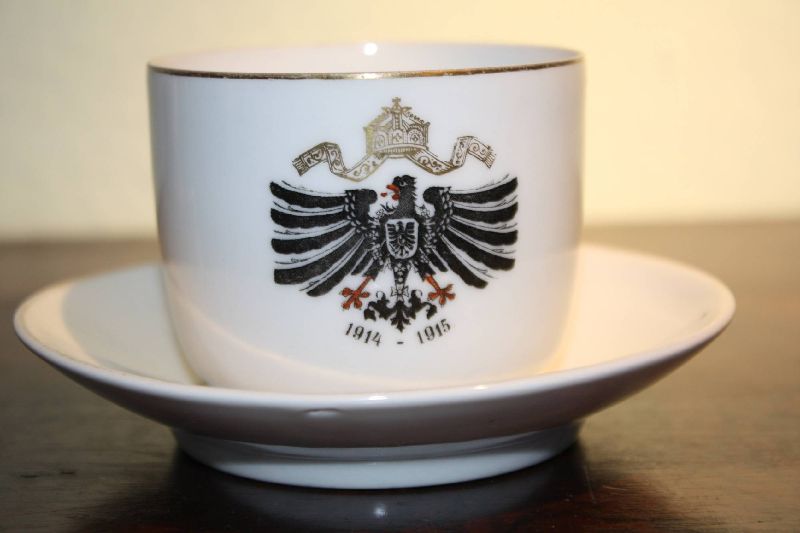 A German patriotic cup and saucer, black eagle with a crown and annual figures