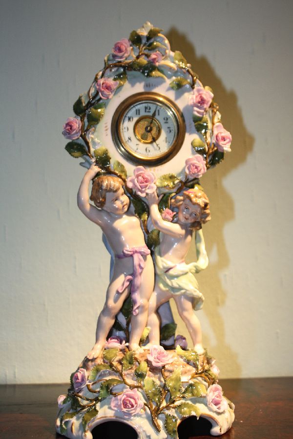 A vintage figurative 1910 porcelain mantel clock, made by Schierholz, Plaue, Germany