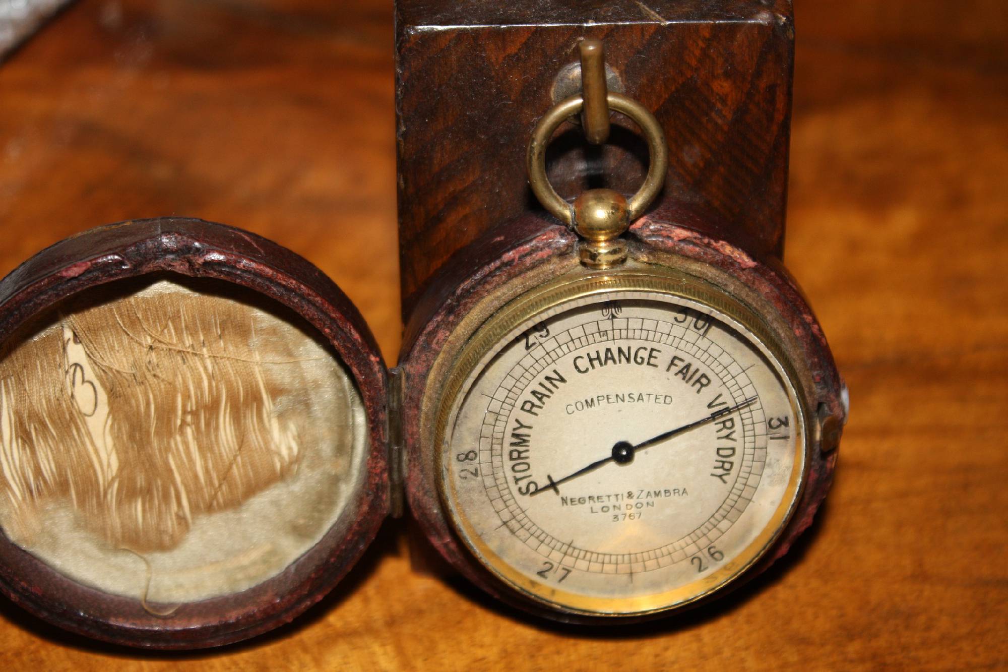 Small antique English travel-size brass barometer in a leather case, made by 'Negretti & Zambra', London