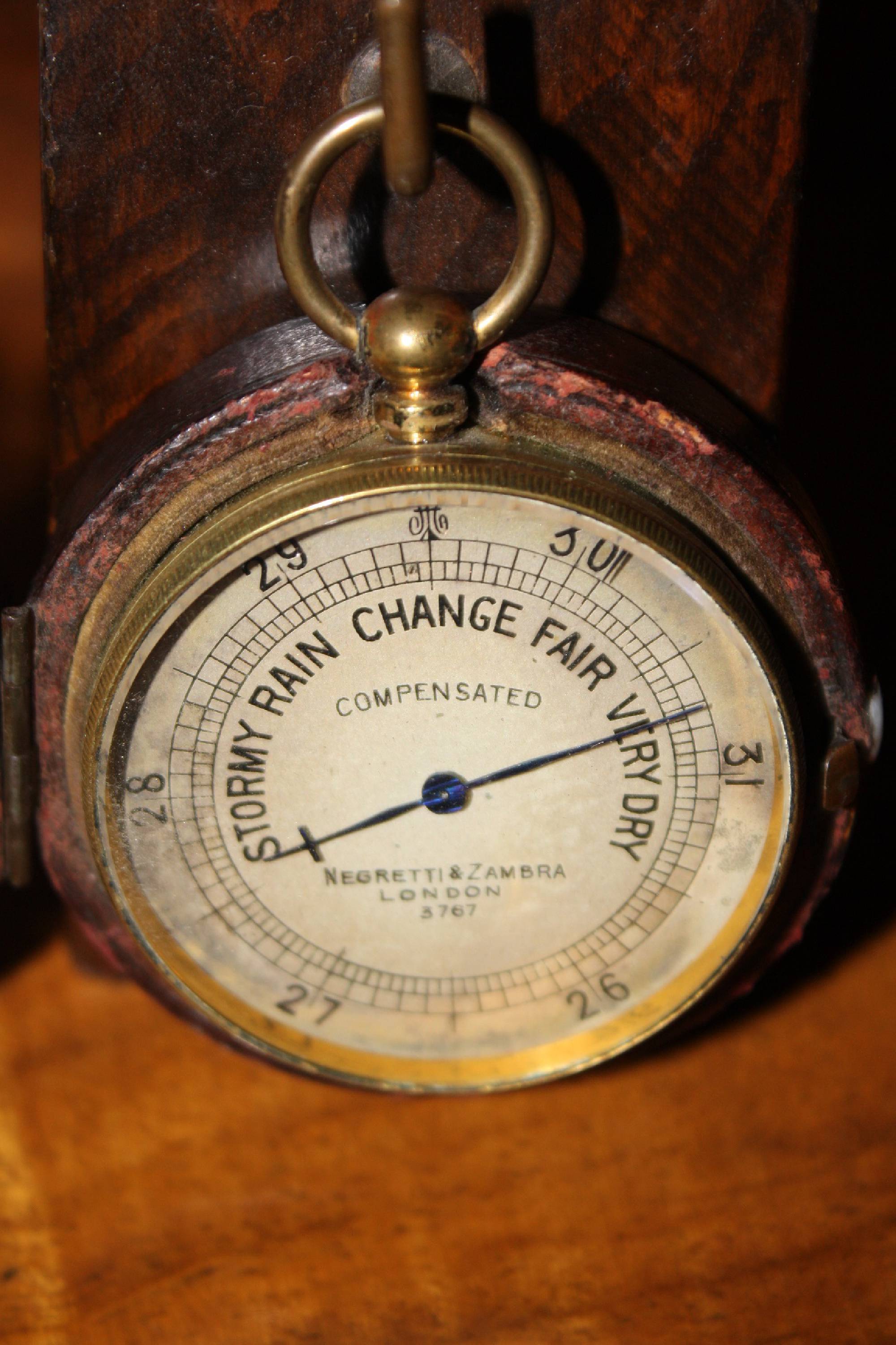 Small antique English travel-size brass barometer in a leather case, made by 'Negretti & Zambra', London