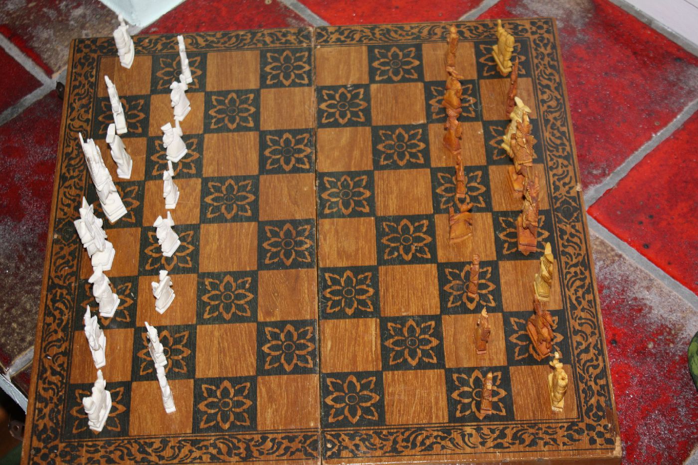 A 1920's Chinese handcarved ivory chess game with a wooden case serves as a fold-up playing board