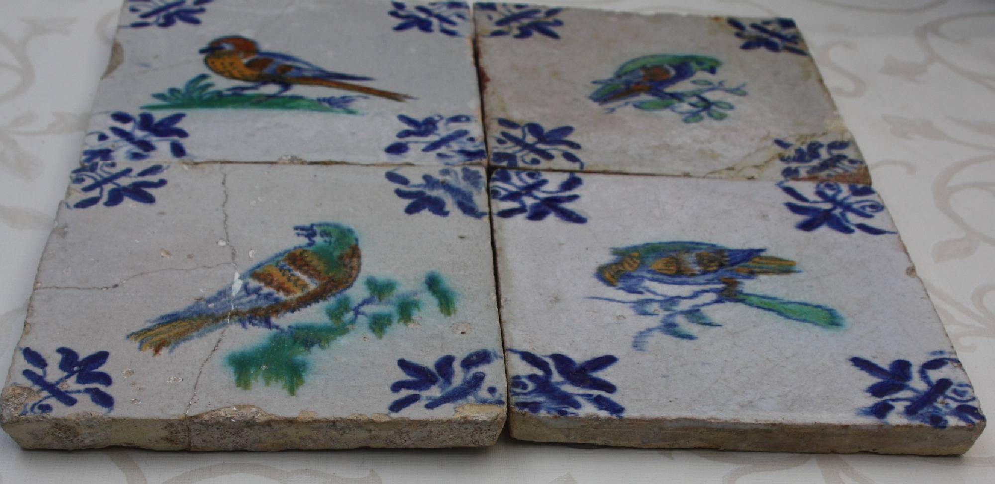 Four antique hand-painted Dutch, first half 17th century polychrome Delft stoneware bird tiles