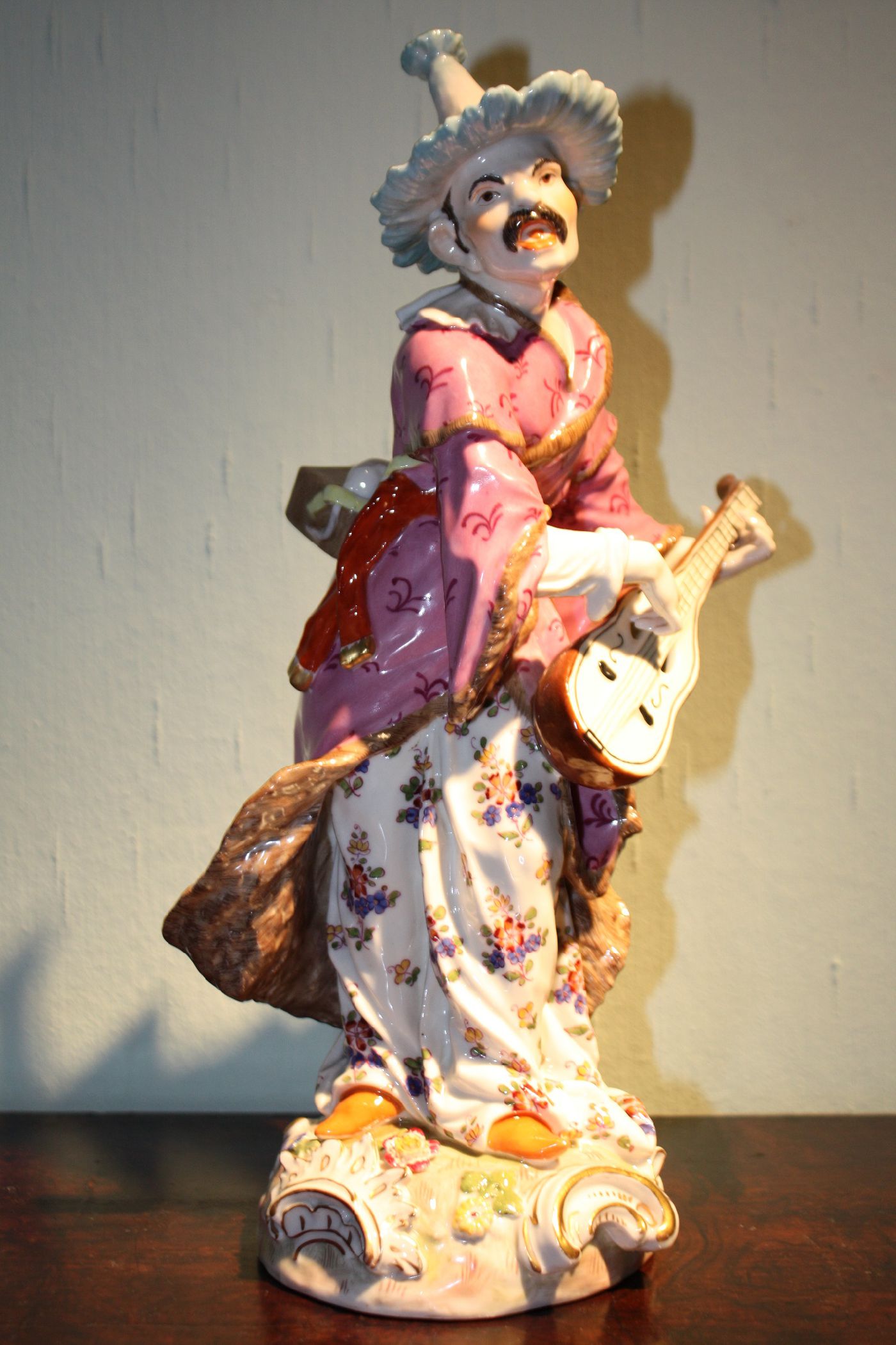 A big antique 19th century handpainted porcelain figure of a musician playing mandolin and singing, by Volkstedt Rudolstadt