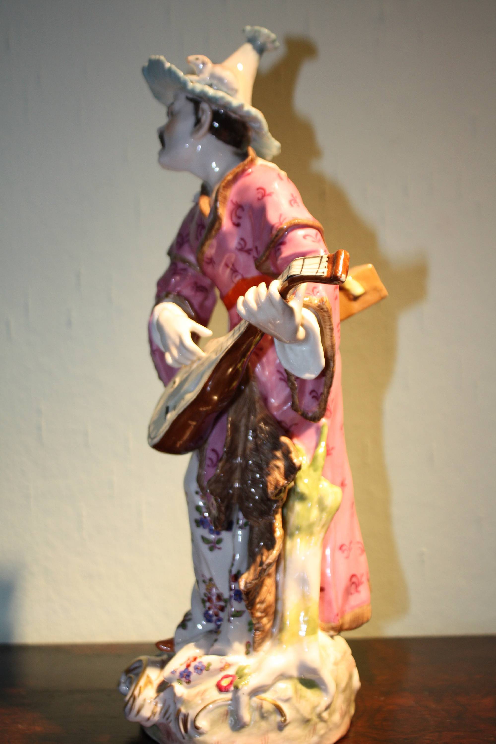 A big antique 19th century handpainted porcelain figure of a musician playing mandolin and singing, by Volkstedt Rudolstadt